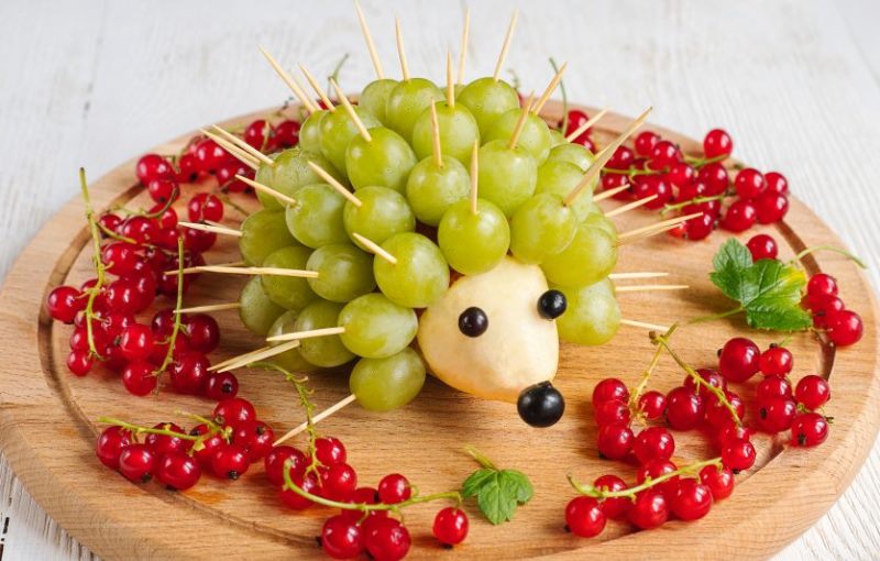 Украшение стола: съедобный ежик из груши и винограда